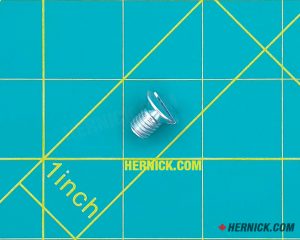 Metal M8 × 12 mm Phillips recessed countersunk machine screw on a green background with yellow grid marks.