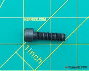 Black socket head bolt on a green background with yellow grid marks.