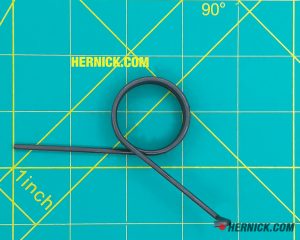 coiled steel extension spring on a green background with yellow grid markings.