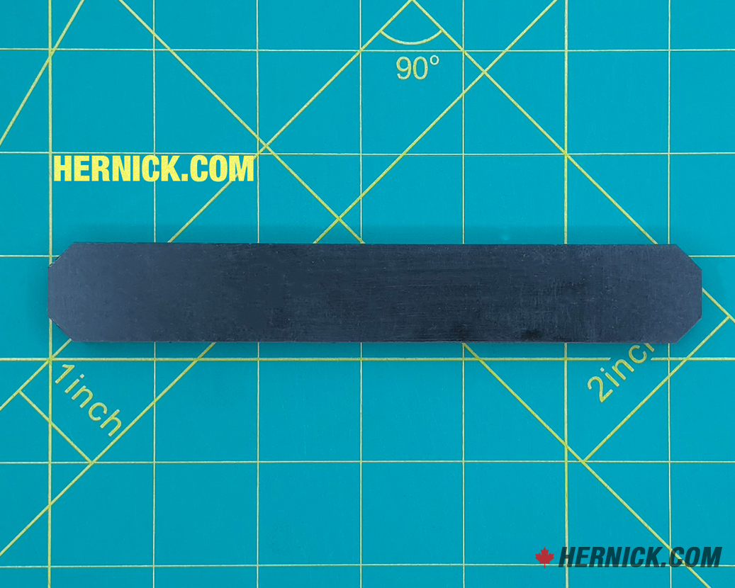 Rectangular high-wear polymer slider wear strip on a green background with yellow grid marks.